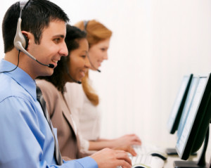 man smiling behind computer in call center