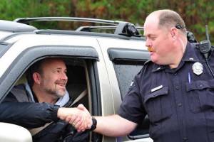 Policeman shaking hands with a driver