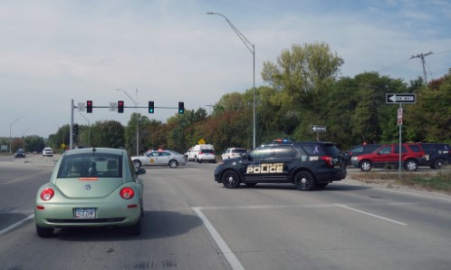 Traffic cop stops intersection traffic after wreck.