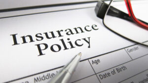 An insurance policy with a pen resting on top.