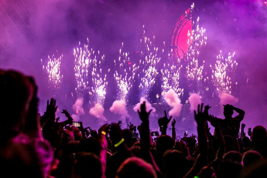 Purple pyrotechnics shooting from a stage at a music festival in Chicago, IL