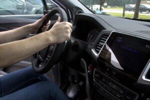 A person driving a car with their hands on the wheel in Illinois.
