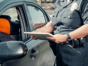 Police Officer Standing Next to the Gray Car