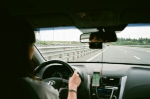 Woman driving on the road looking in rear view mirror